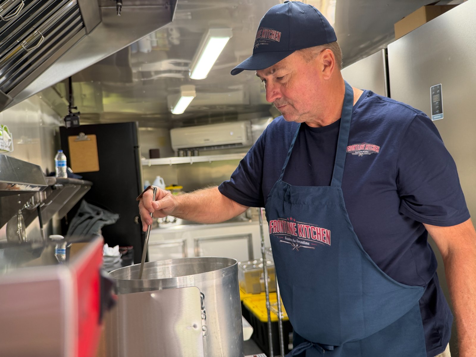 Stirring a stockpot of meals for a deployment