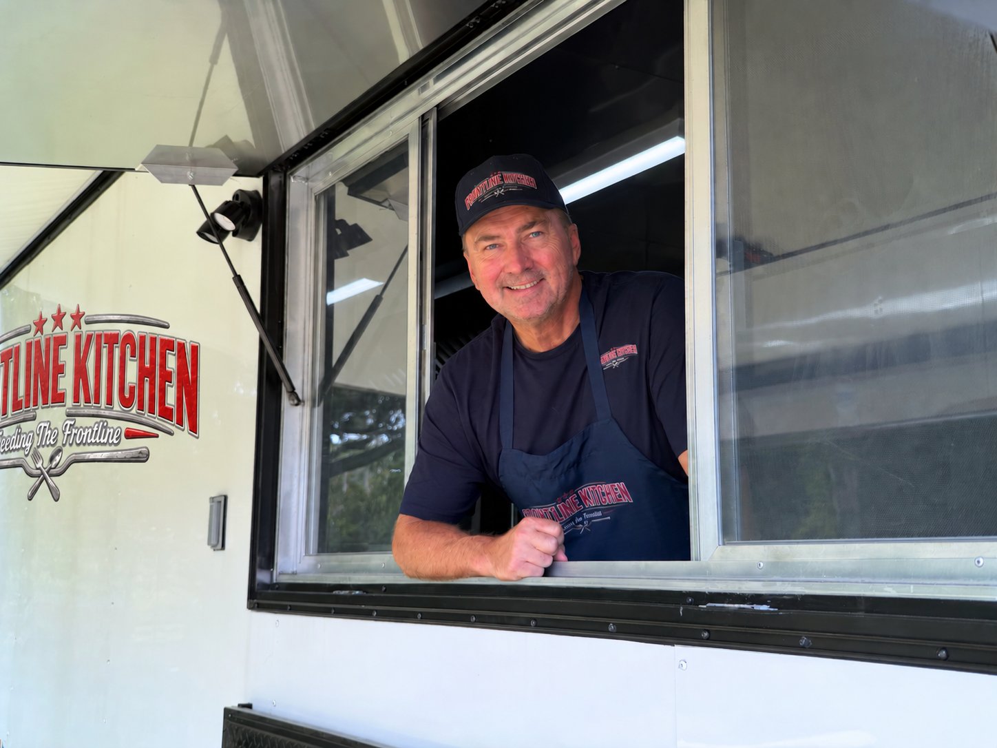 Frontline Kitchen founder at the service window of the food truck